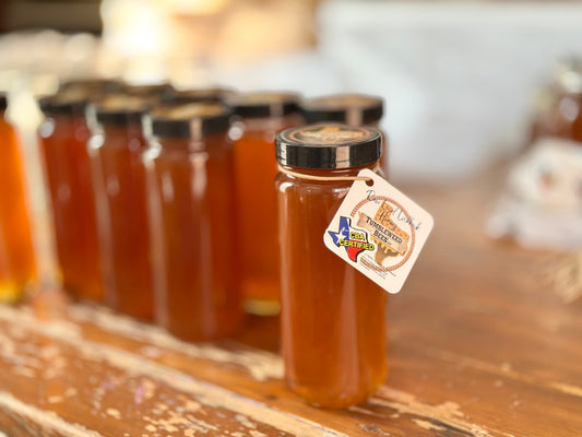 Jars of honey with a visible label on a wooden surface